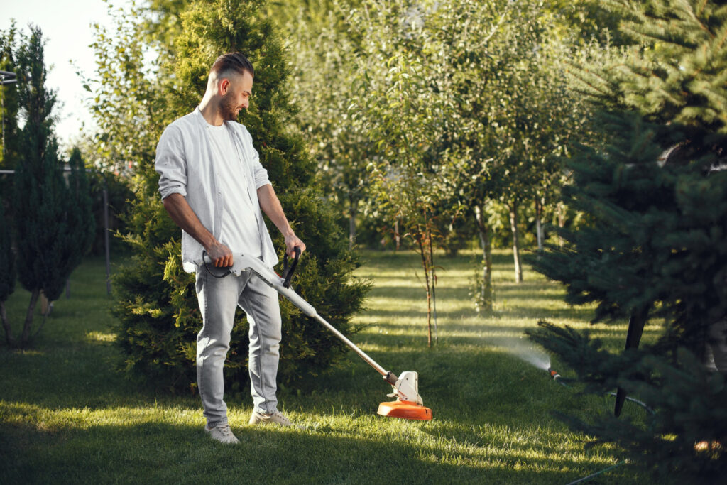 man cutting grass with lawn mower